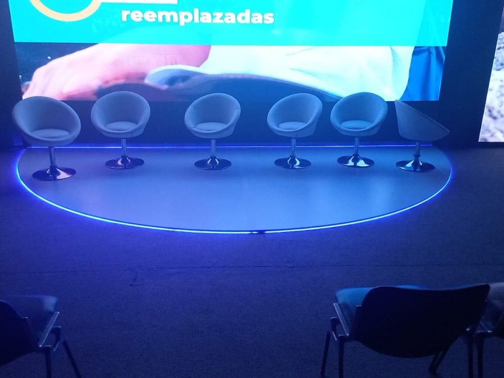 Tarima equipada con pantalla LED y sillas para convenciones, diseñada por BRA Publicidad SAS
